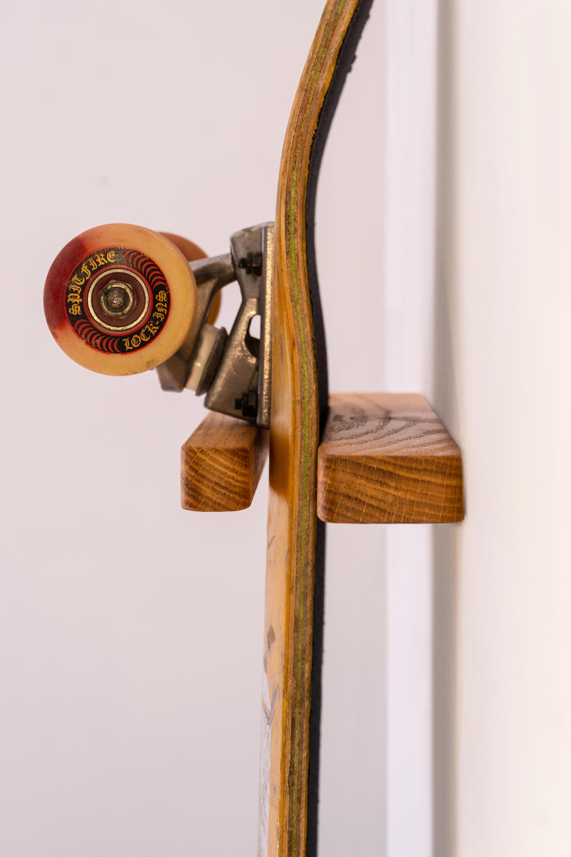 Skateboard accroché au mur sur un support mural vertical en chêne massif