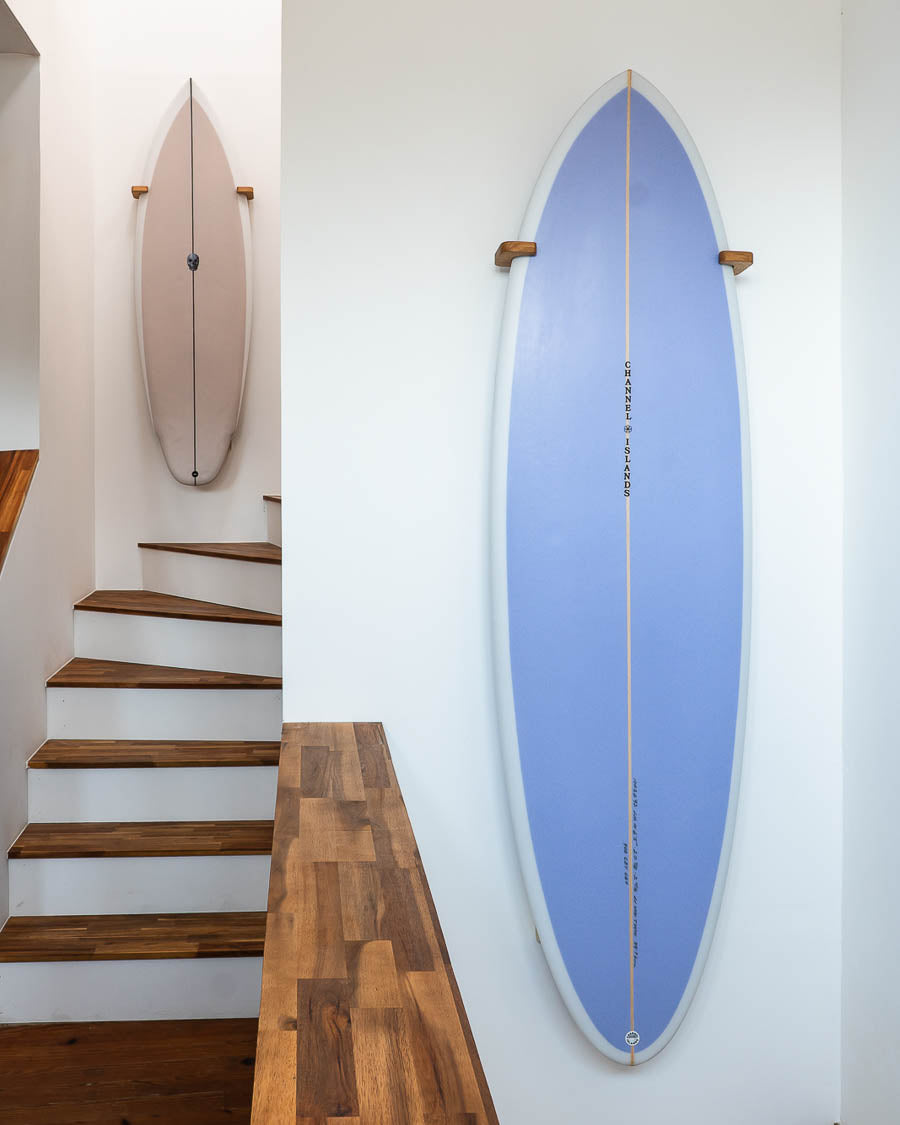 Deux twin fin et midlenght accrochés au mur dans une cage d'escalier