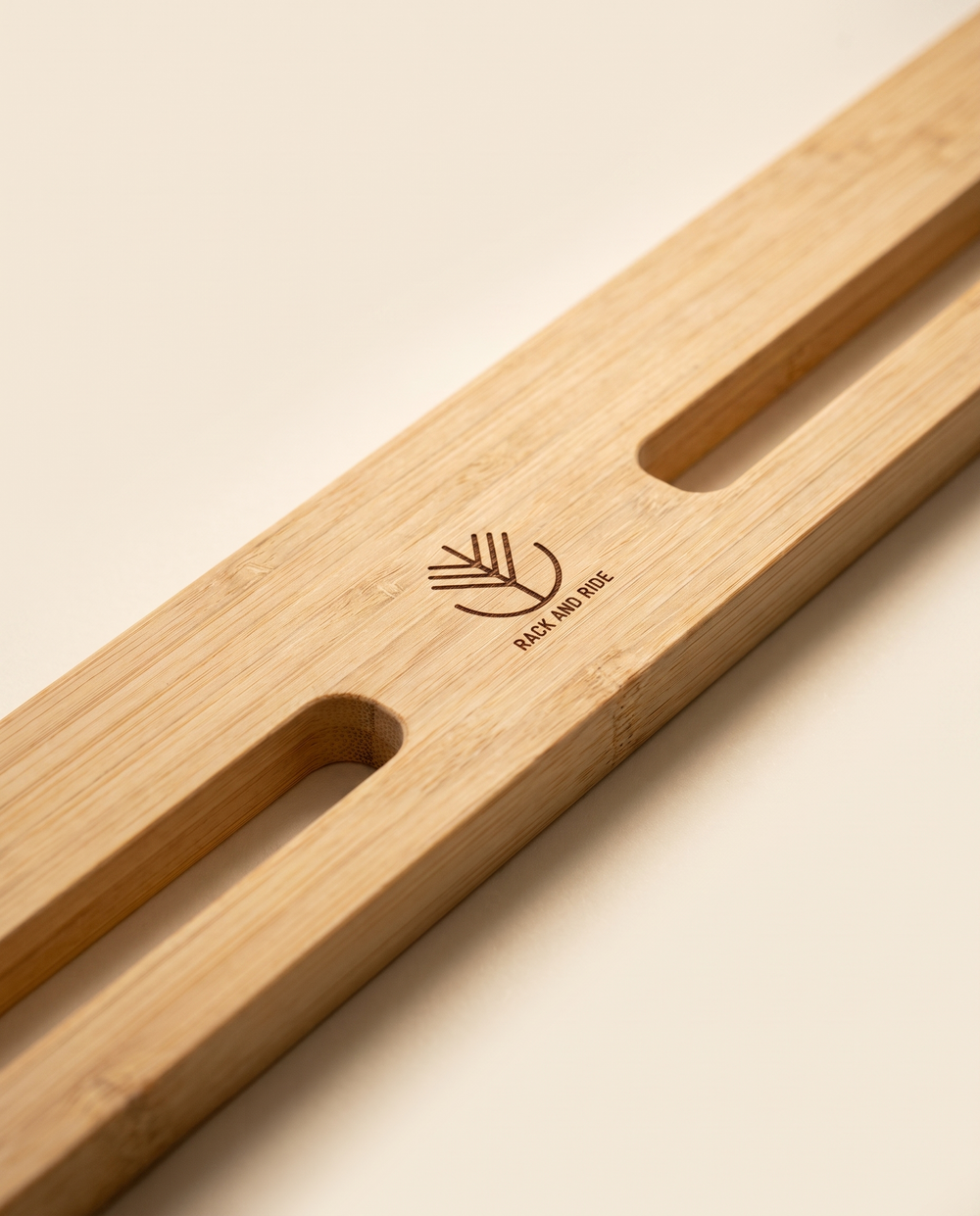 Close-up of the bamboo grain and engraved logo on the double skateboard wall mount