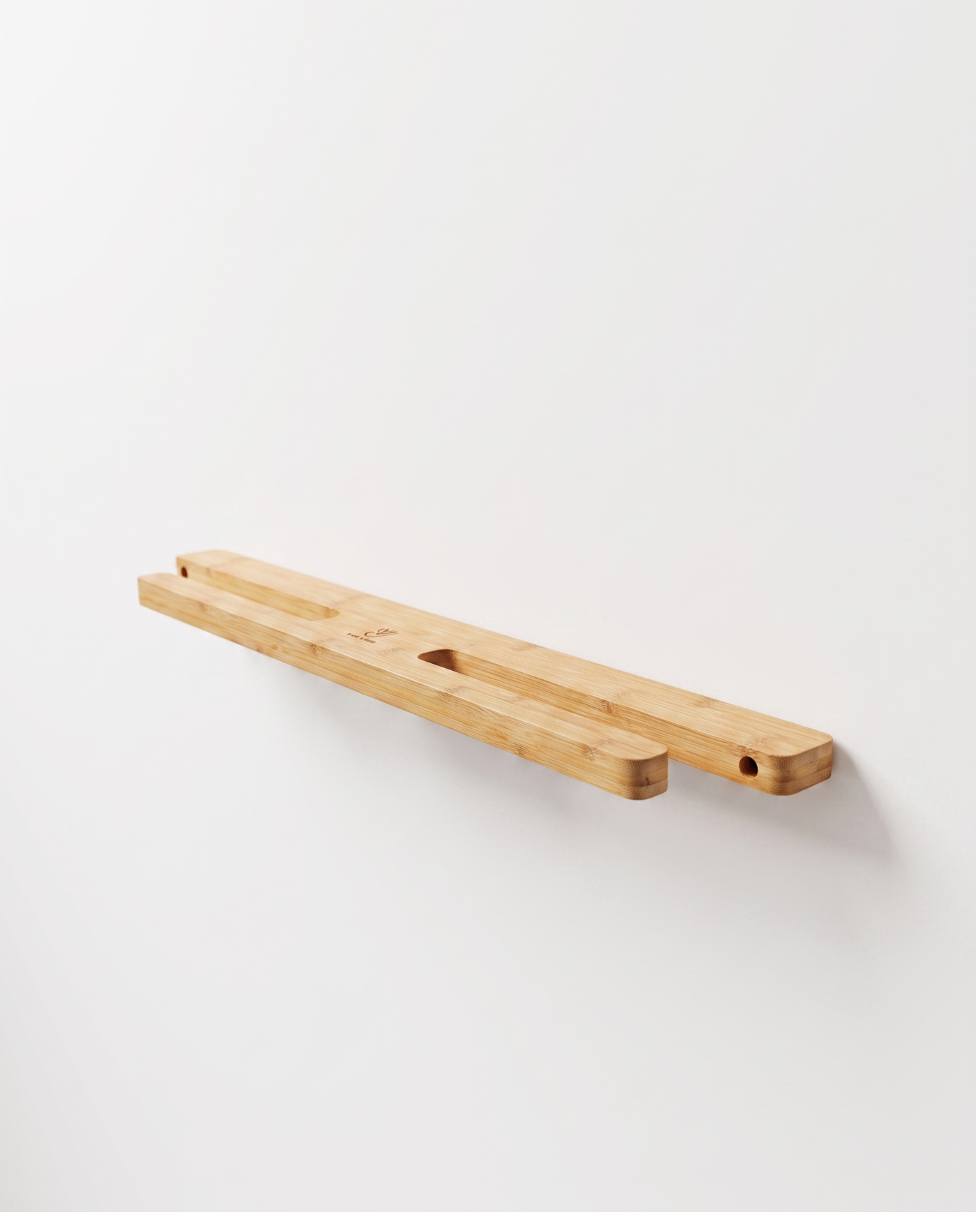 Close-up of a skateboard held by its trucks on the bamboo double wall mount