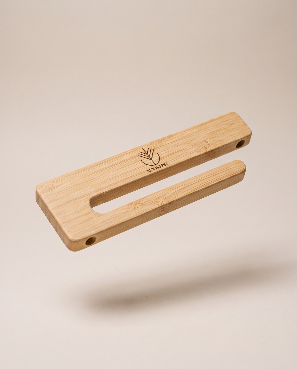 Bamboo wall mount holding a skateboard by its trucks, the deck graphic visible and unscratched