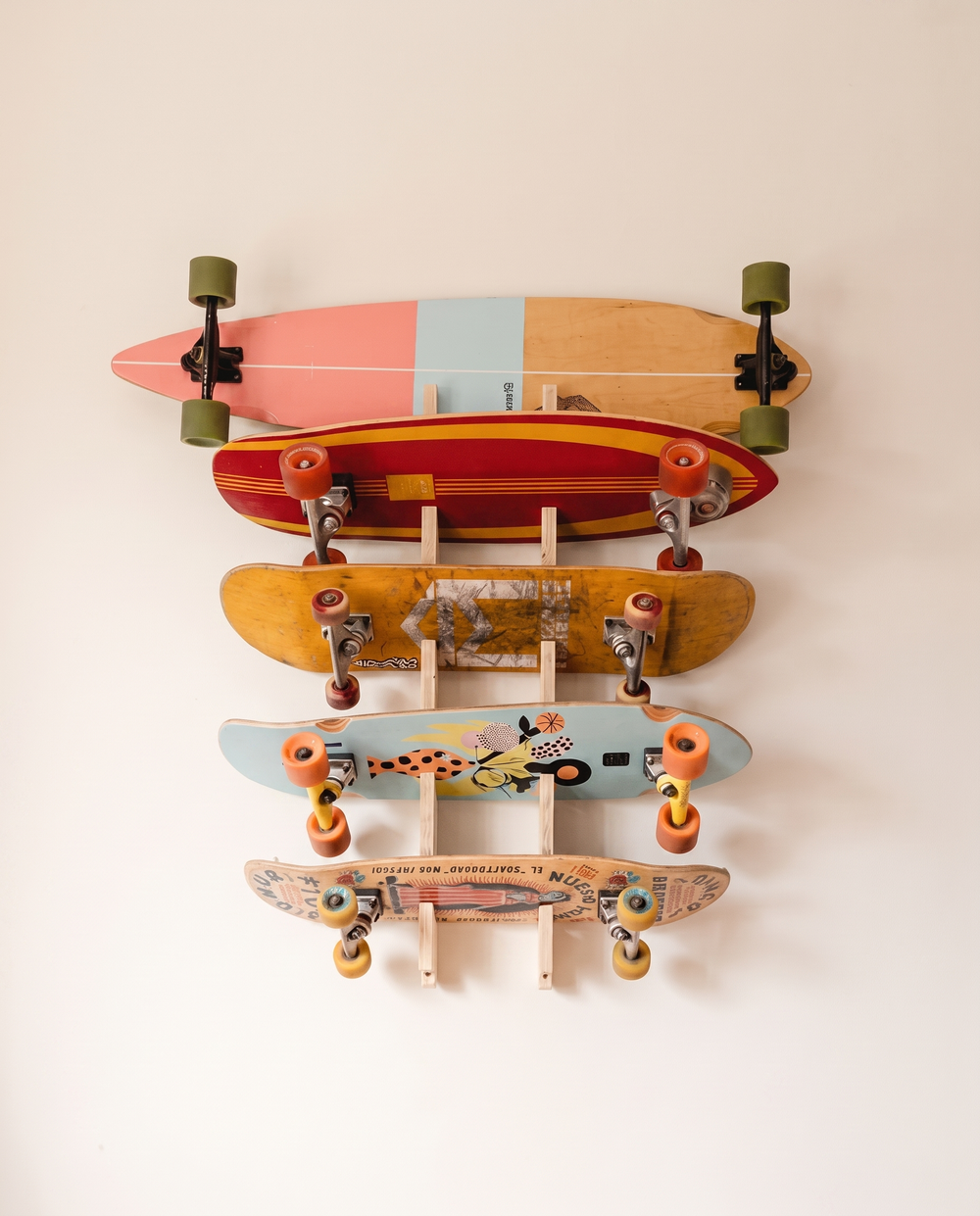 Plywood 5-board rack fully loaded with a snowboard and four skateboards