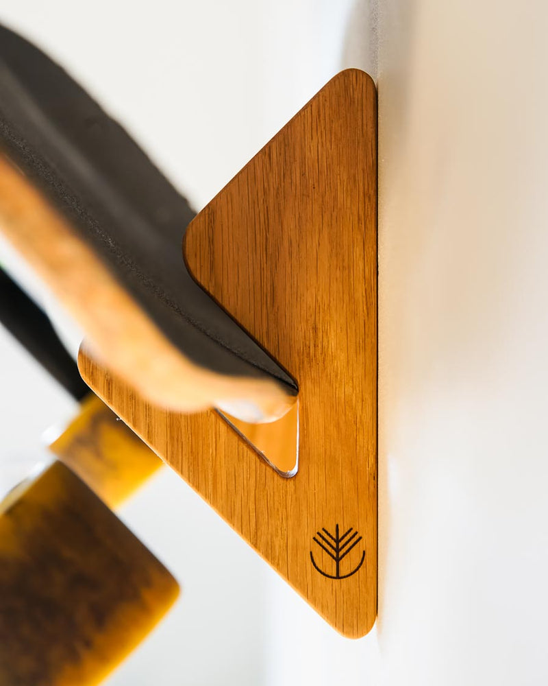 Skateboard-Wandhalterung aus Eiche, die ein Deck mit der Grafik nach vorn an der Wand zeigt
