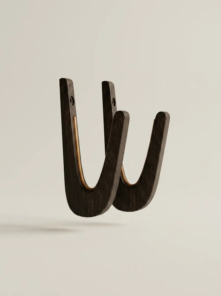 Cork-lined cradle of a black-tinted oak surfboard wall rack protecting a board rail