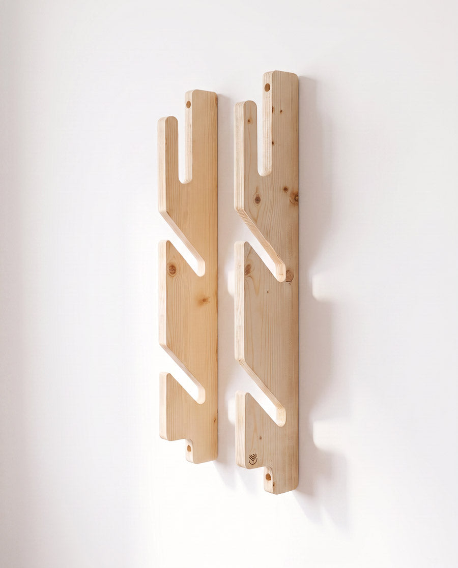Les deux rails à encoches en 3 plis épicéa du rack boardsport triple, vides sur un mur blanc